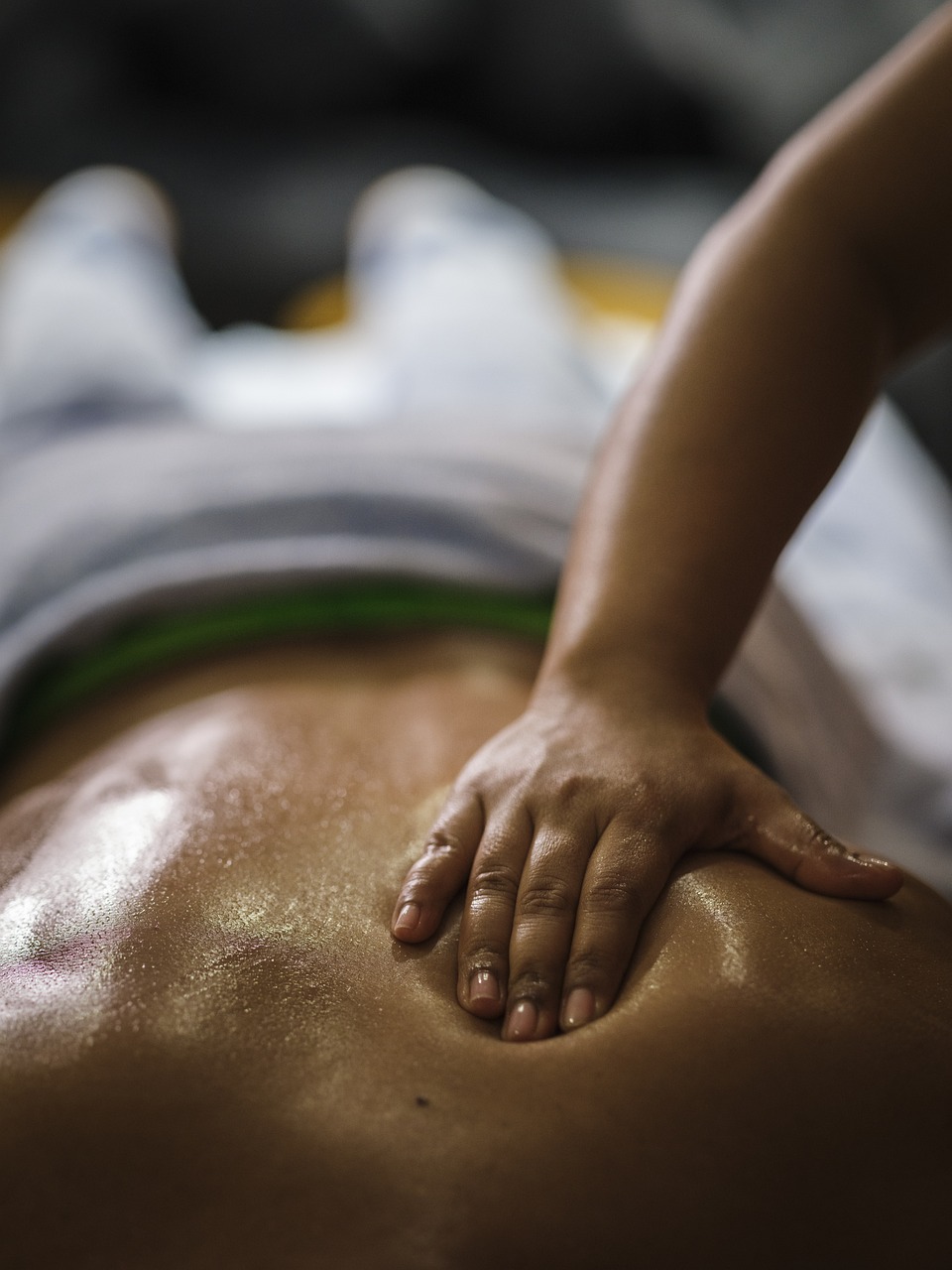 Vue rapprochée des mains expertes de la masseuse effectuant un drainage lymphatique sur la jambe d'une cliente à Bouc-Bel-Air